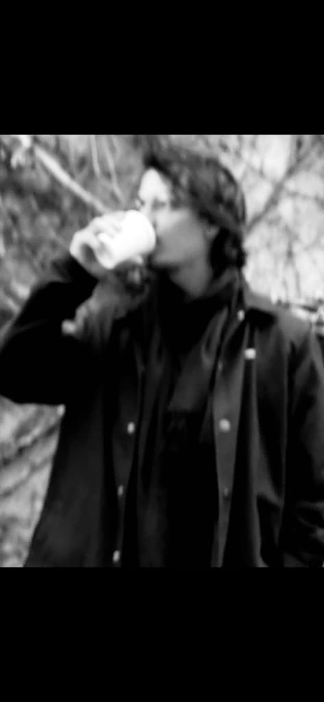 maxdecoyer de perfil, casaco escuro, tomando café